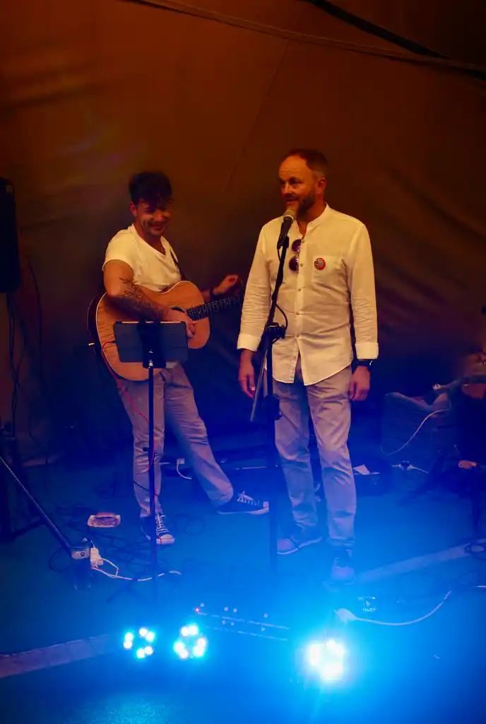 Aaron Norton playing while the birthday guest of honour sings along at a 60th party