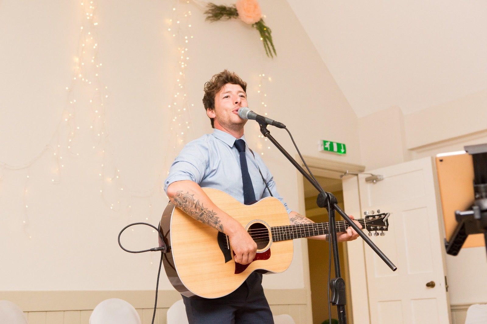 Aaron Norton playing live acoustic guitar and singing at a private party